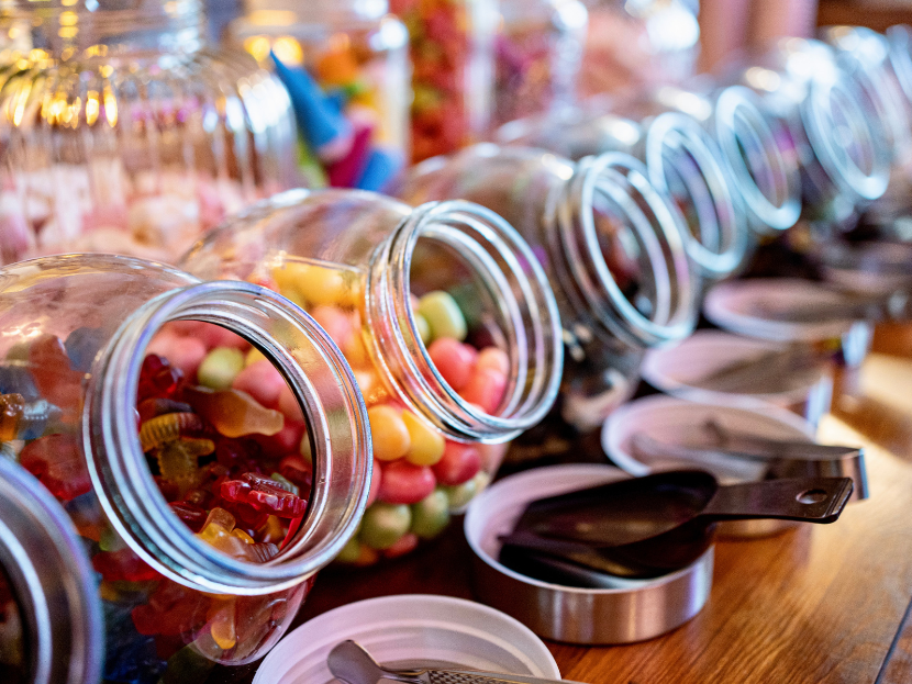 Eine Candybar mit verschiedenen Gläsern gefüllt mit unterschiedlichen Arten von Süßigkeiten. Von bunten Gummibärchen bis Schokolade.