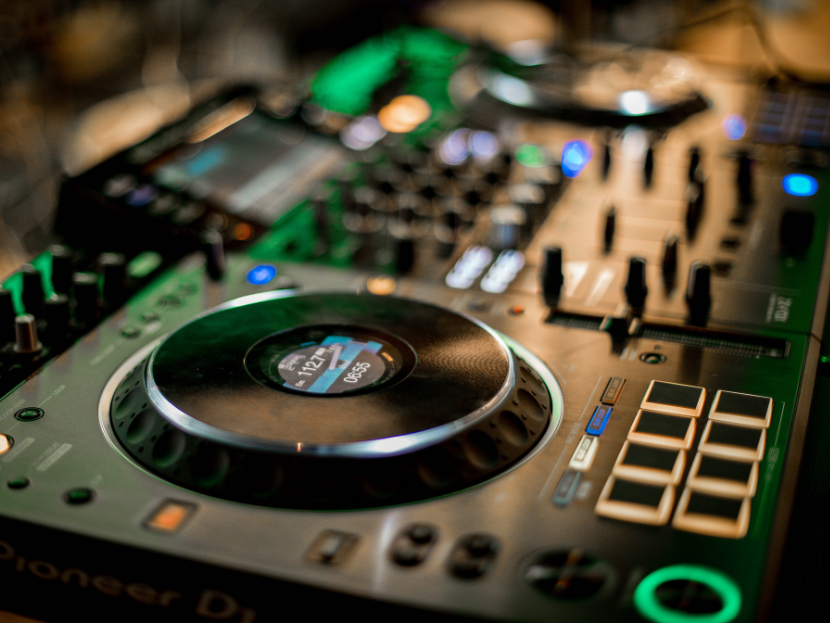 Ein schwarzes DJ Pult, mit vielen Knöpfen und einer Drehscheibe.