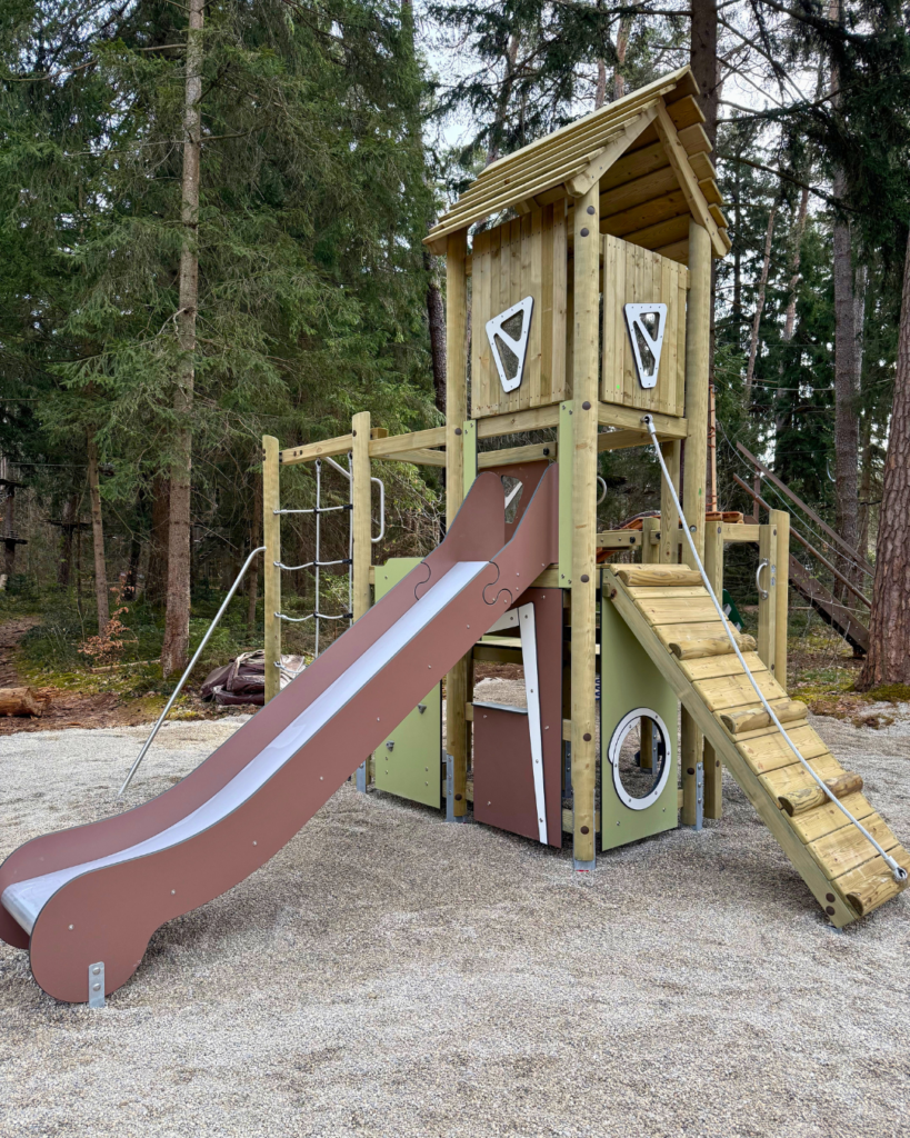 Ein Klettergerüst mit einer Rutsche und einem hohen Turm.